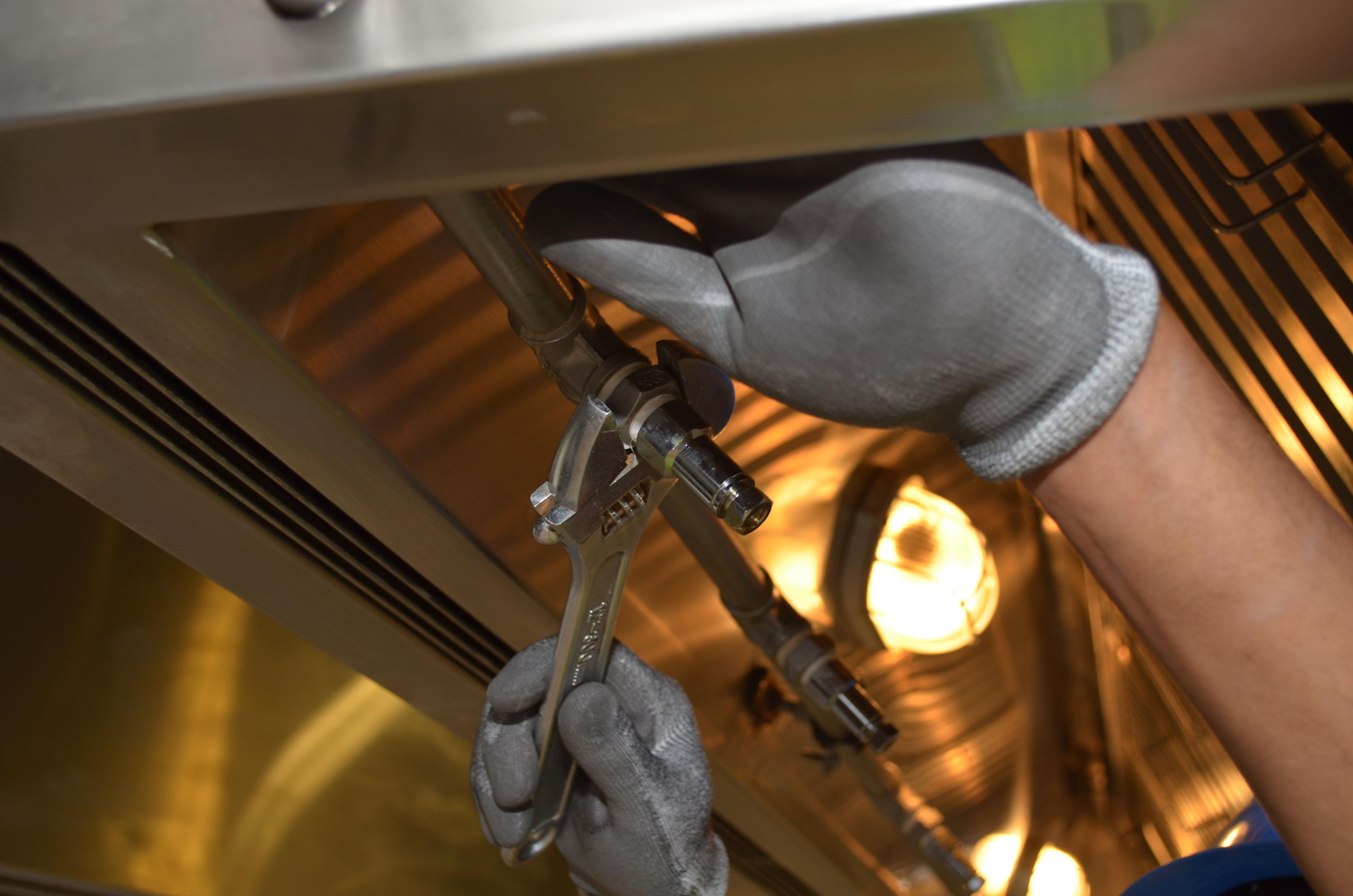 Worker fixing pipes with a wrench