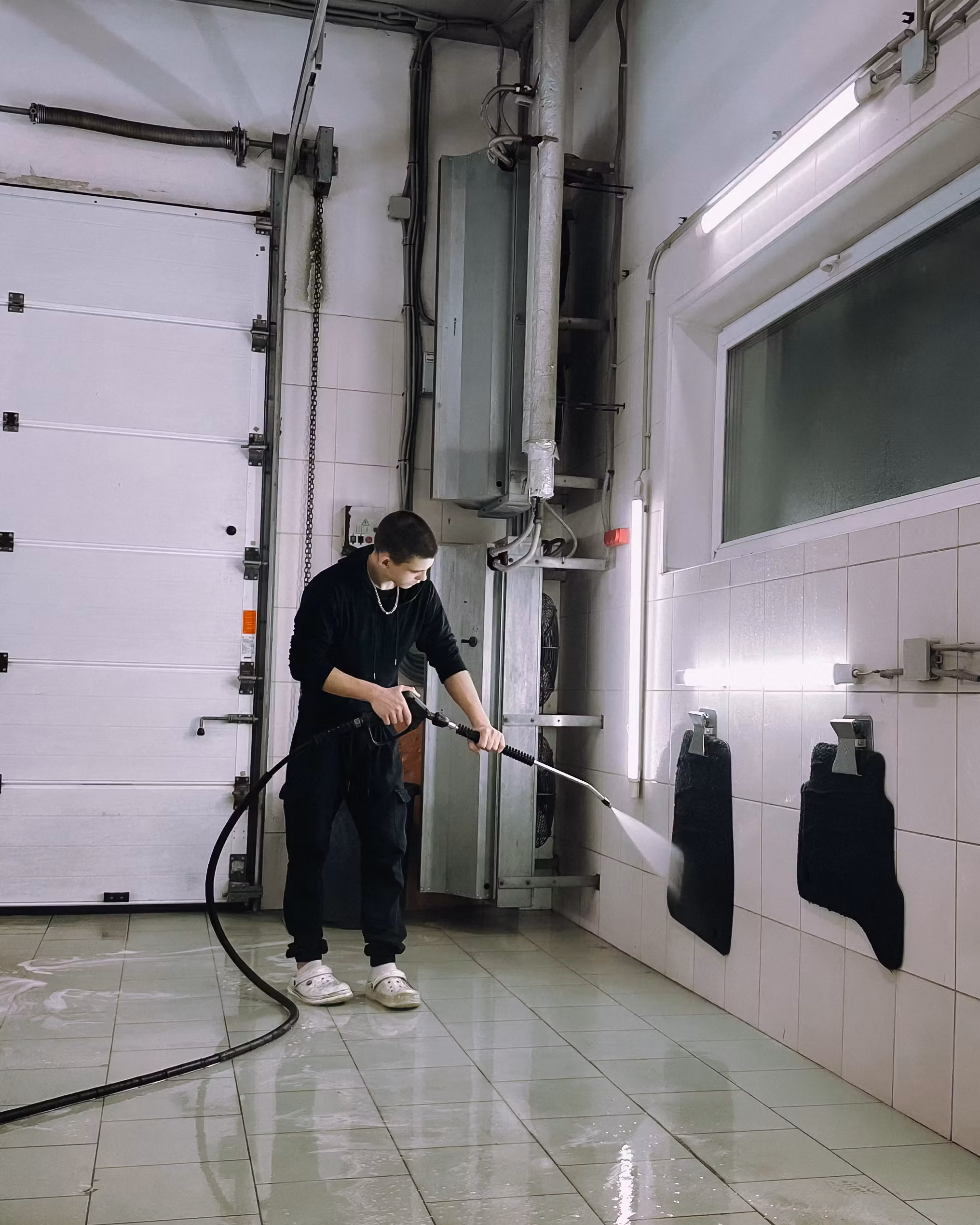 Worker using a power washer